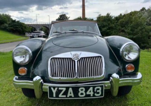 Front view of a classic green MGA Roadster parked on grass